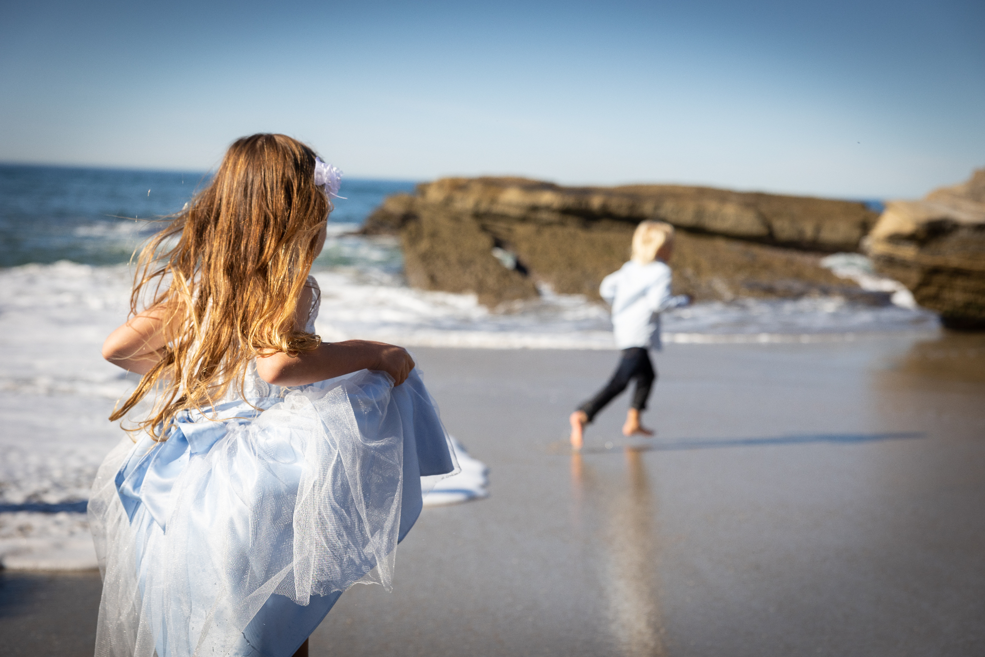 Children playing on the beach at the water's edge